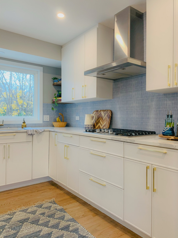 Inspiration for a mid-sized modern l-shaped kitchen in New York with an undermount sink, flat-panel cabinets, white cabinets, quartzite benchtops, blue splashback, ceramic splashback, stainless steel appliances, medium hardwood floors, with island, brown floor and white benchtop.