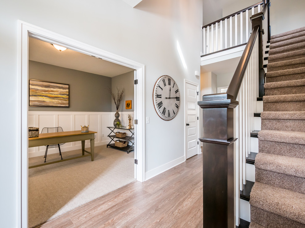 Photo of a mid-sized arts and crafts foyer in Other with white walls, light hardwood floors, a single front door and a brown front door.