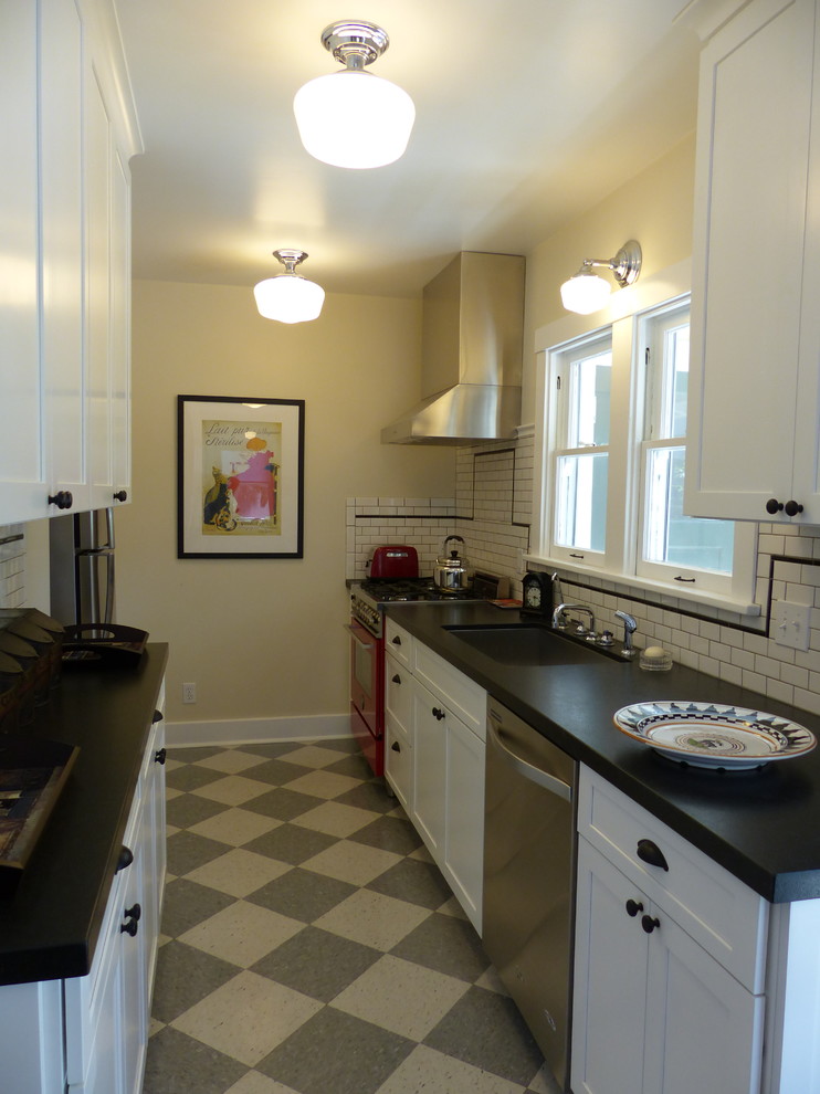This is an example of a mid-sized arts and crafts galley kitchen in Santa Barbara with a single-bowl sink, shaker cabinets, white cabinets, granite benchtops, white splashback, subway tile splashback, stainless steel appliances, linoleum floors and no island.