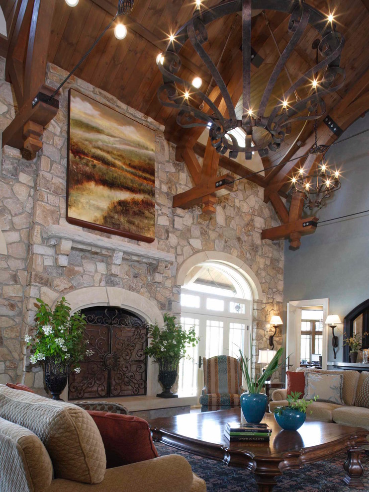 Inspiration for a mediterranean open concept living room in New York with grey walls, a standard fireplace, a stone fireplace surround, no tv and beige floor.