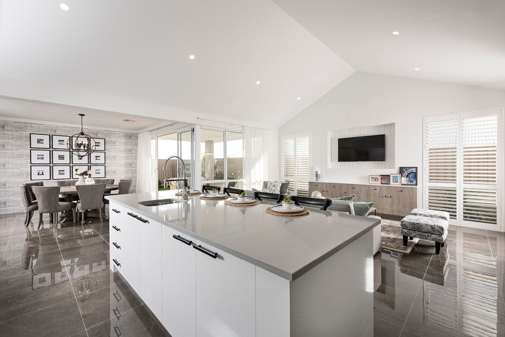 This is an example of a large transitional galley open plan kitchen in Perth with an undermount sink, flat-panel cabinets, white cabinets, quartz benchtops, grey splashback, porcelain splashback, stainless steel appliances, porcelain floors, with island and grey floor.