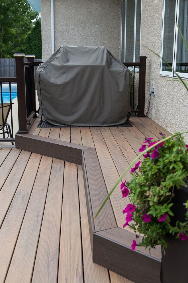 Example of a mid-sized transitional backyard deck design with no cover