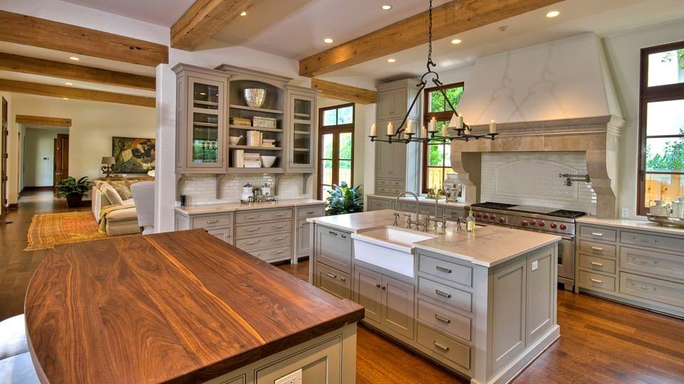 Photo of a large country open plan kitchen in Denver with a farmhouse sink, recessed-panel cabinets, grey cabinets, granite benchtops, white splashback, stainless steel appliances, medium hardwood floors and multiple islands.