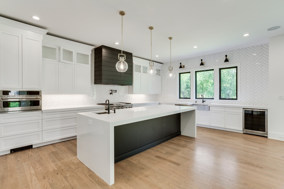 Enclosed kitchen - mid-sized contemporary medium tone wood floor enclosed kitchen idea in Other with an undermount sink, shaker cabinets, white cabinets, quartz countertops, white backsplash, stainless steel appliances, an island and white countertops