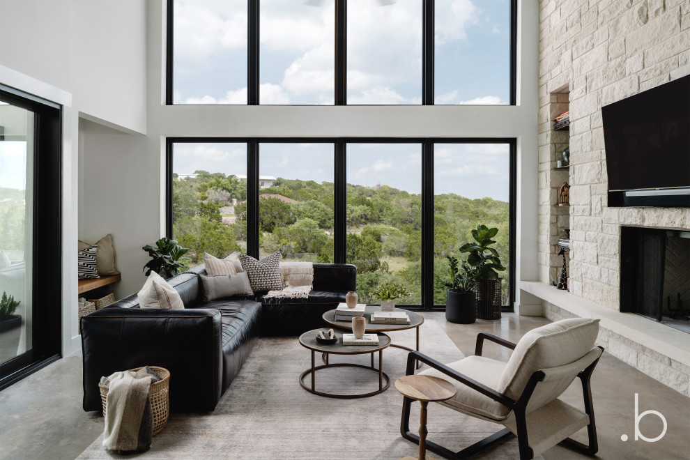 Mittelgroßes, Offenes Modernes Wohnzimmer mit Kaminumrandung aus Stein und TV-Wand in Austin