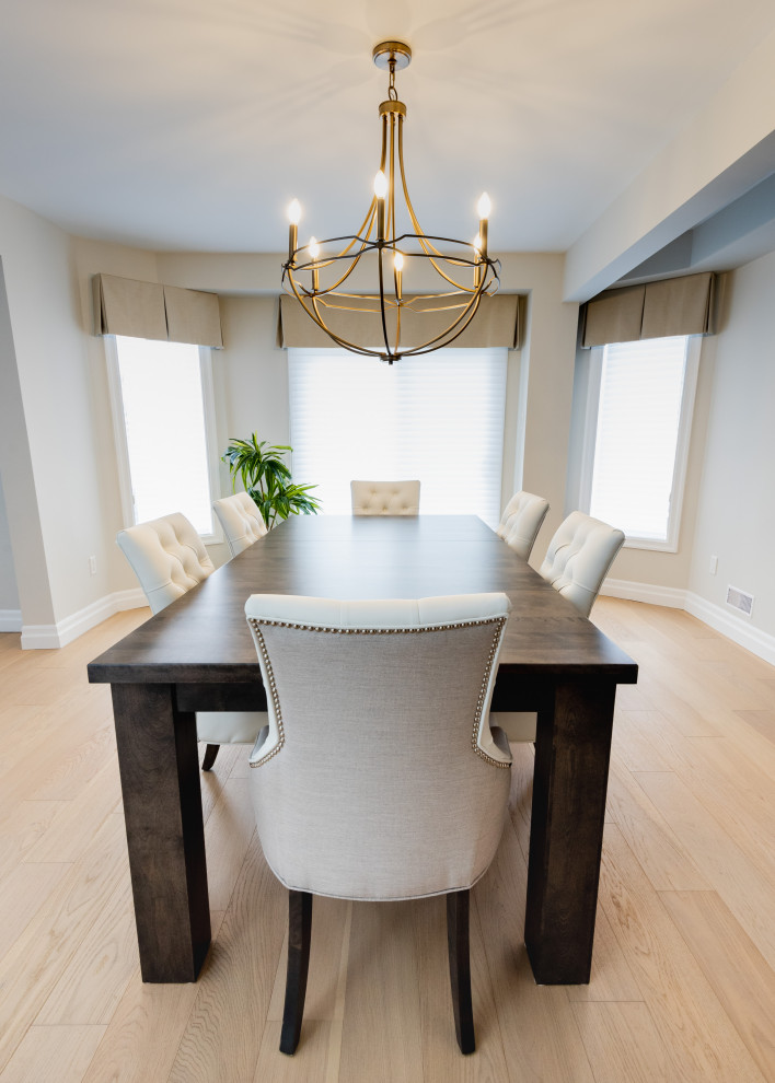 Exemple d'une salle à manger ouverte sur la cuisine tendance de taille moyenne avec un mur blanc, parquet clair et un sol marron.