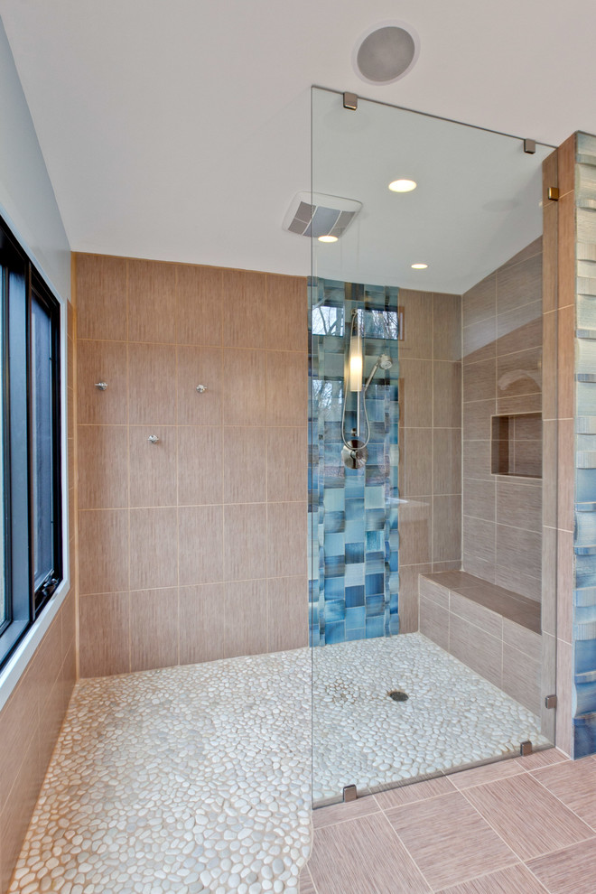 Large modern master bathroom in Charlotte with an open shower, white tile, pebble tile, brown walls and pebble tile floors.