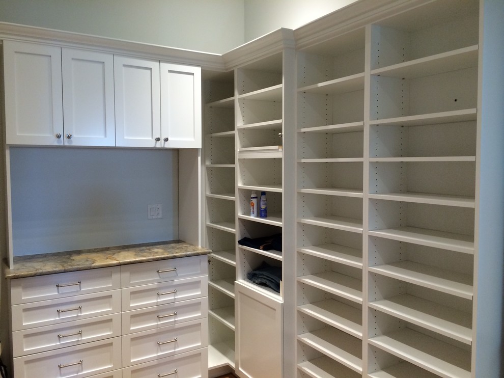 This is an example of a large beach style gender-neutral walk-in wardrobe in Miami with open cabinets and white cabinets.