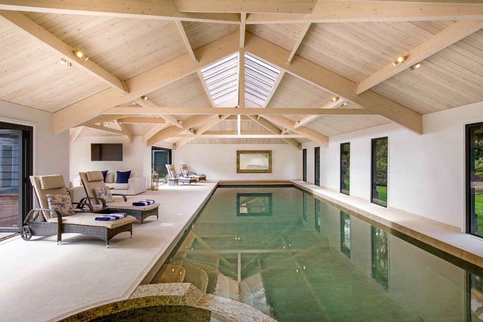 Photo of a contemporary indoor rectangular lap pool in London with a pool house.