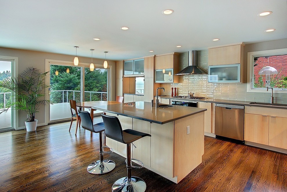 This is an example of a contemporary kitchen in Seattle with stainless steel appliances and subway tile splashback.