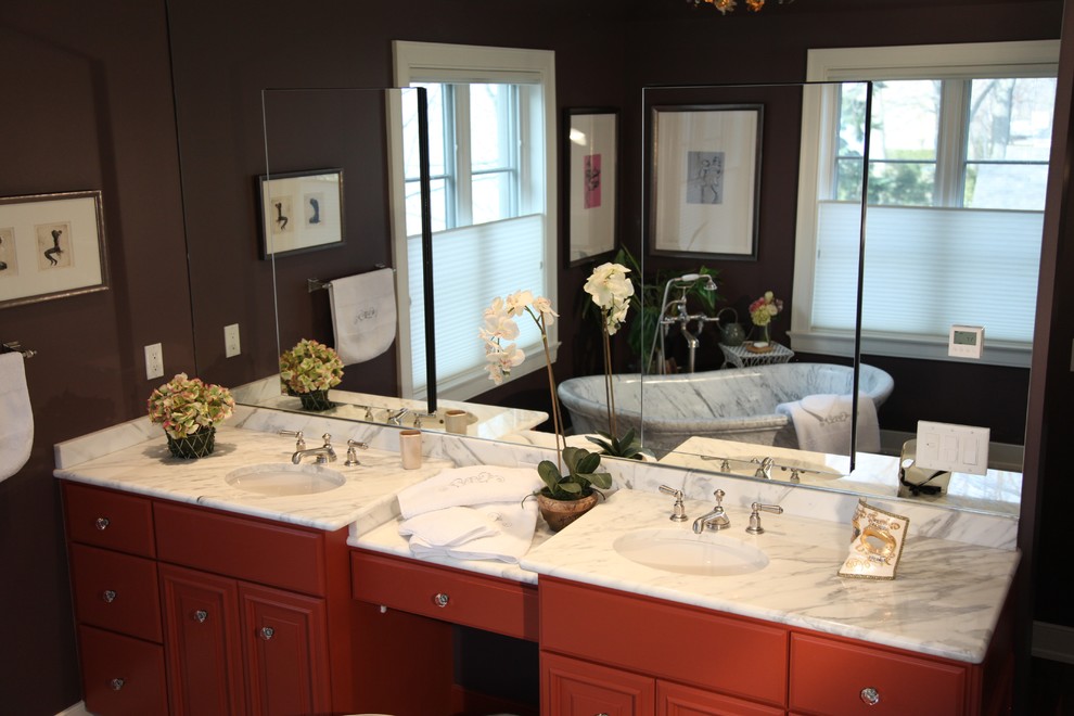 Inspiration for a large transitional master bathroom in Milwaukee with an undermount sink, raised-panel cabinets, red cabinets, marble benchtops, a freestanding tub, an alcove shower, a one-piece toilet, white tile, stone tile, purple walls and marble floors.