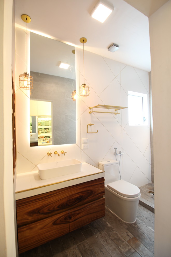Photo of a mid-sized modern master bathroom in Other with glass-front cabinets, medium wood cabinets, a curbless shower, a bidet, white tile, porcelain tile, white walls, cement tiles, a vessel sink, tile benchtops, grey floor and a hinged shower door.