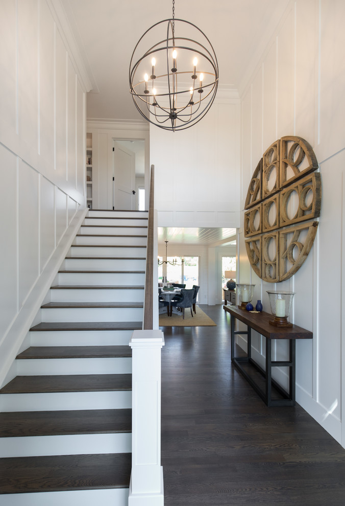 This is an example of a large country wood straight staircase in Calgary with painted wood risers and wood railing.