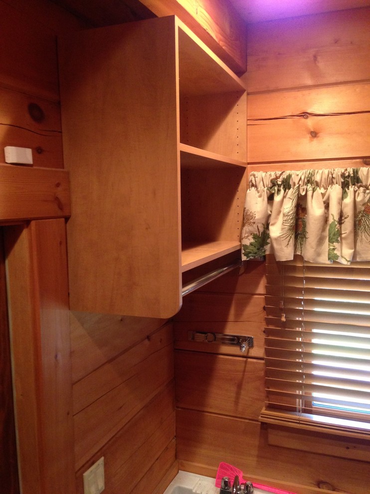 Example of a mid-sized mountain style gender-neutral and single-wall carpeted home design design with open cabinets, medium tone wood cabinets, brown walls and a side-by-side washer/dryer