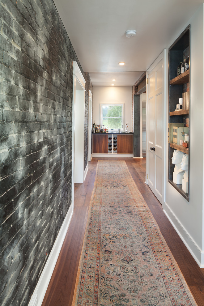 This is an example of a mid-sized industrial hallway in DC Metro with black walls and medium hardwood floors.