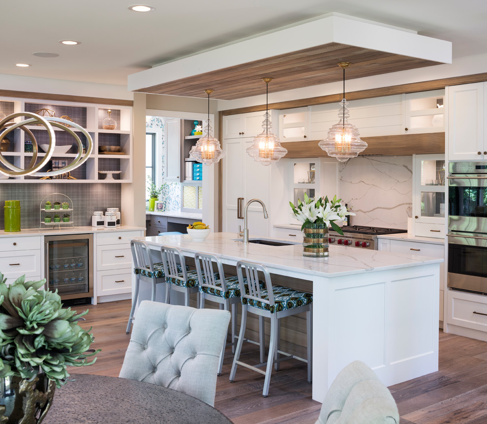Inspiration for a large transitional single-wall eat-in kitchen in Minneapolis with an undermount sink, shaker cabinets, white cabinets, marble benchtops, white splashback, stone slab splashback, stainless steel appliances, dark hardwood floors and with island.