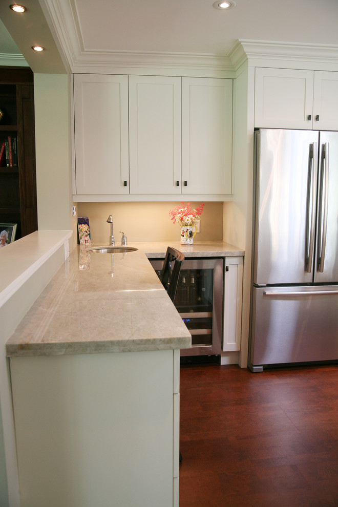 Eat-in kitchen - large transitional l-shaped dark wood floor and brown floor eat-in kitchen idea in Toronto with an undermount sink, shaker cabinets, white cabinets, stainless steel appliances and an island