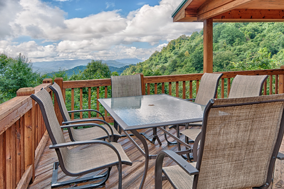 Mid-sized mountain style backyard balcony deck photo with a roof extension
