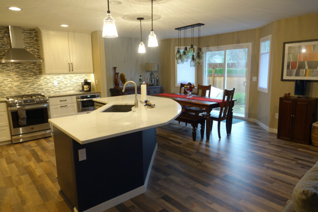 Example of a mid-sized transitional eat-in kitchen design in Seattle with an undermount sink, shaker cabinets, quartzite countertops, glass tile backsplash, stainless steel appliances, an island and white countertops