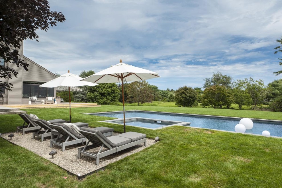 This is an example of a large contemporary backyard custom-shaped pool in New York.