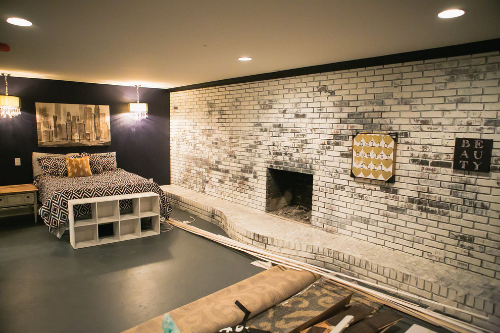 Photo of a mid-sized eclectic master bedroom in Nashville with white walls, concrete floors, a standard fireplace and a brick fireplace surround.