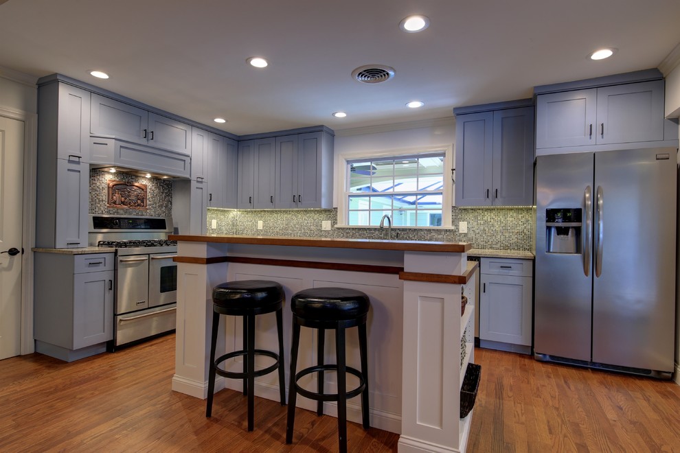 Design ideas for a mid-sized arts and crafts l-shaped separate kitchen in Tampa with an undermount sink, shaker cabinets, grey cabinets, granite benchtops, multi-coloured splashback, mosaic tile splashback, stainless steel appliances, dark hardwood floors, with island and brown floor.
