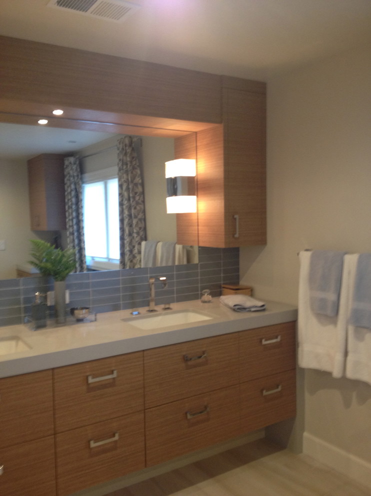 Freestanding bathtub - mid-sized transitional master blue tile and subway tile light wood floor and blue floor freestanding bathtub idea with flat-panel cabinets, distressed cabinets, beige walls, an undermount sink, solid surface countertops and a hinged shower door
