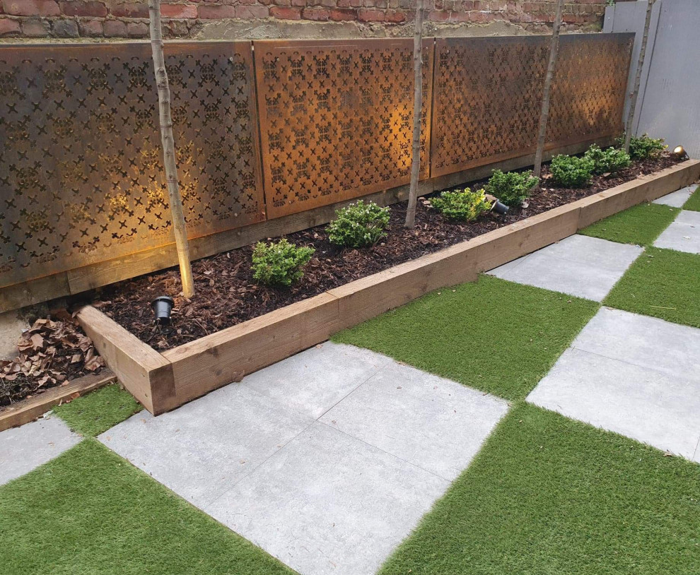 This is an example of a medium sized contemporary courtyard patio in London with tiled flooring and no cover.