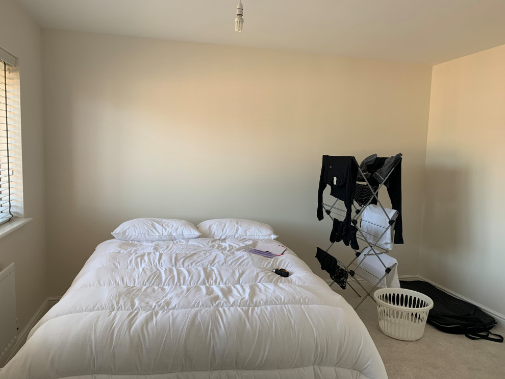 Inspiration pour une chambre minimaliste de taille moyenne avec un mur bleu et un sol beige.