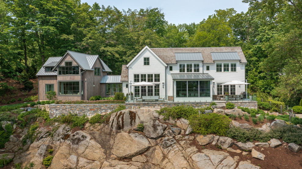Large transitional multicolored two-story wood and clapboard gable roof photo with a mixed material roof and a brown roof