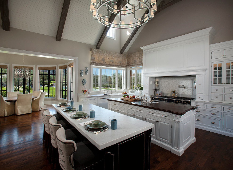 Example of a transitional eat-in kitchen design in Phoenix with an undermount sink, raised-panel cabinets, white cabinets, wood countertops and gray backsplash