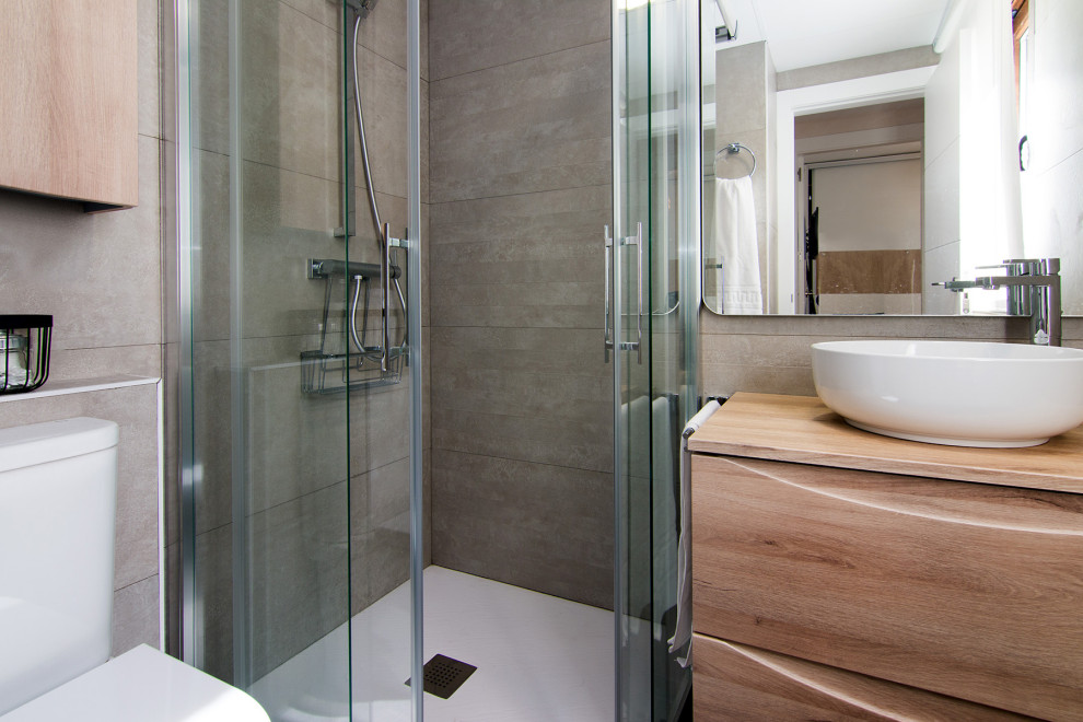 Exempel på ett nordiskt badrum, med vita skåp, en hörndusch, en vägghängd toalettstol, keramikplattor, grå väggar, klinkergolv i keramik, träbänkskiva och grått golv