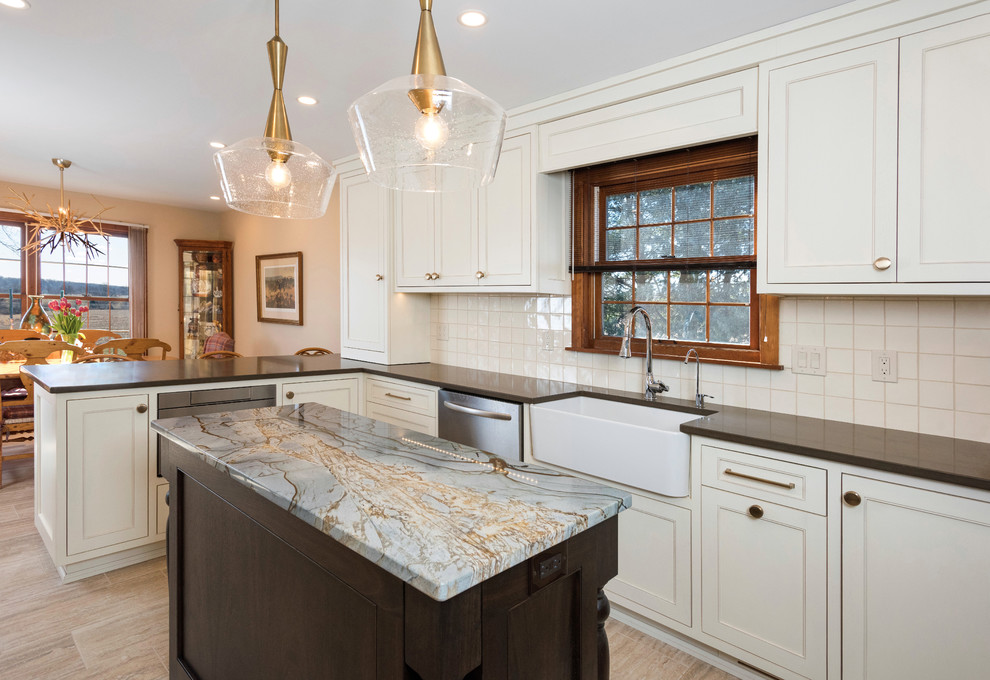 This is an example of a mid-sized transitional u-shaped eat-in kitchen in New York with a farmhouse sink, shaker cabinets, white cabinets, granite benchtops, white splashback, cement tile splashback, stainless steel appliances, with island and brown benchtop.