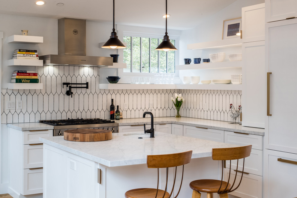 Mid-sized transitional u-shaped eat-in kitchen in Other with a farmhouse sink, shaker cabinets, white cabinets, marble benchtops, white splashback, ceramic splashback, panelled appliances, medium hardwood floors, with island, brown floor, white benchtop and vaulted.