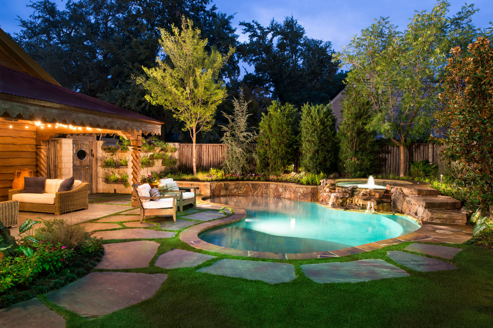 Photo of a small traditional backyard custom-shaped natural pool in Dallas with a hot tub.