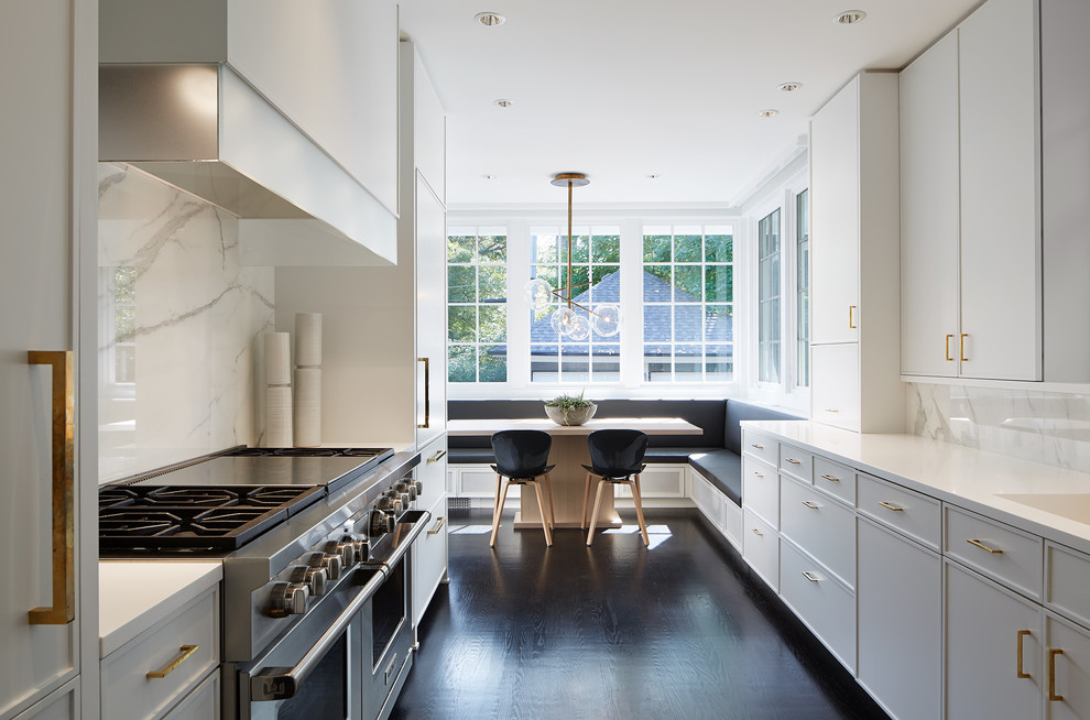 Design ideas for a transitional galley eat-in kitchen in Chicago with white cabinets, white splashback, stone slab splashback, stainless steel appliances and dark hardwood floors.
