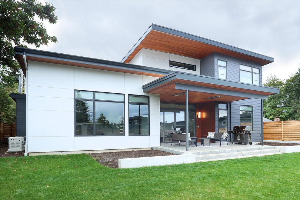Large modern two-storey blue house exterior in Seattle with mixed siding and a flat roof.