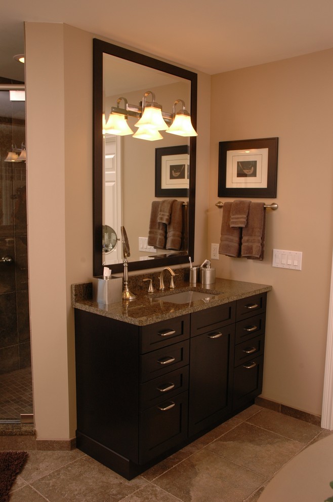 Design ideas for a large traditional master bathroom in Cincinnati with an undermount sink, flat-panel cabinets, dark wood cabinets, granite benchtops, an alcove shower, beige walls and travertine floors.
