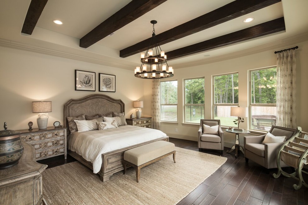 Photo of a mediterranean master bedroom in Houston with beige walls, dark hardwood floors, no fireplace and brown floor.
