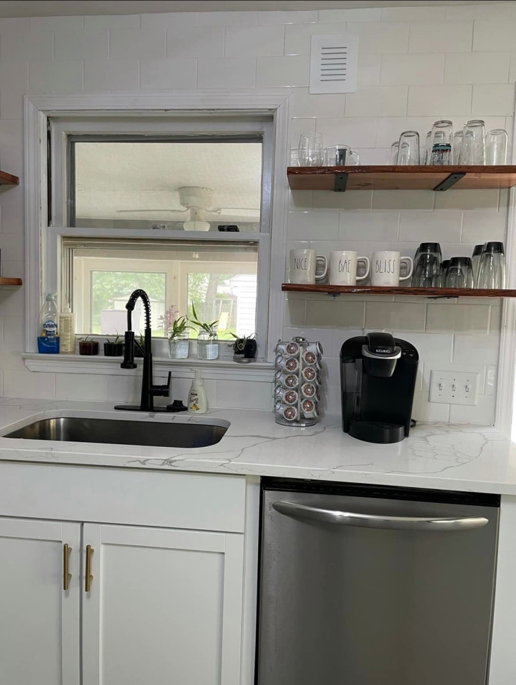 Inspiration for a mid-sized traditional kitchen in Cleveland with an undermount sink, shaker cabinets, white cabinets, white splashback, ceramic splashback, stainless steel appliances, vinyl floors, no island, grey floor and white benchtop.