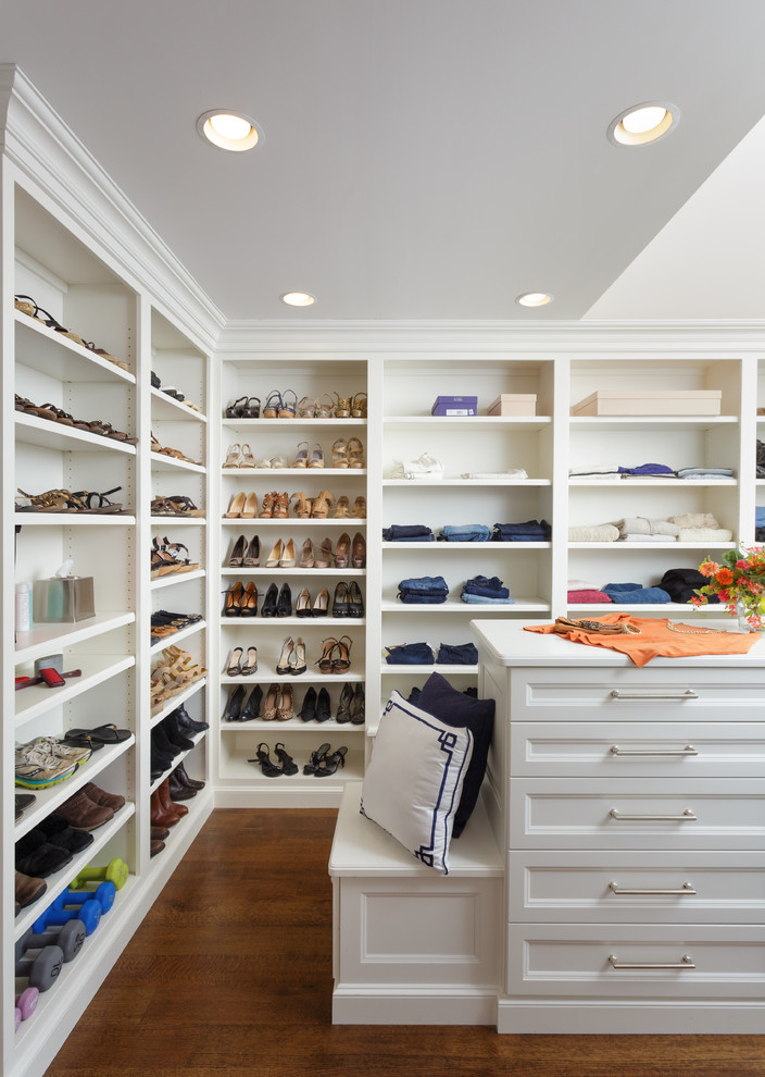This is an example of a women's dressing room in Other with recessed-panel cabinets, white cabinets and dark hardwood floors.