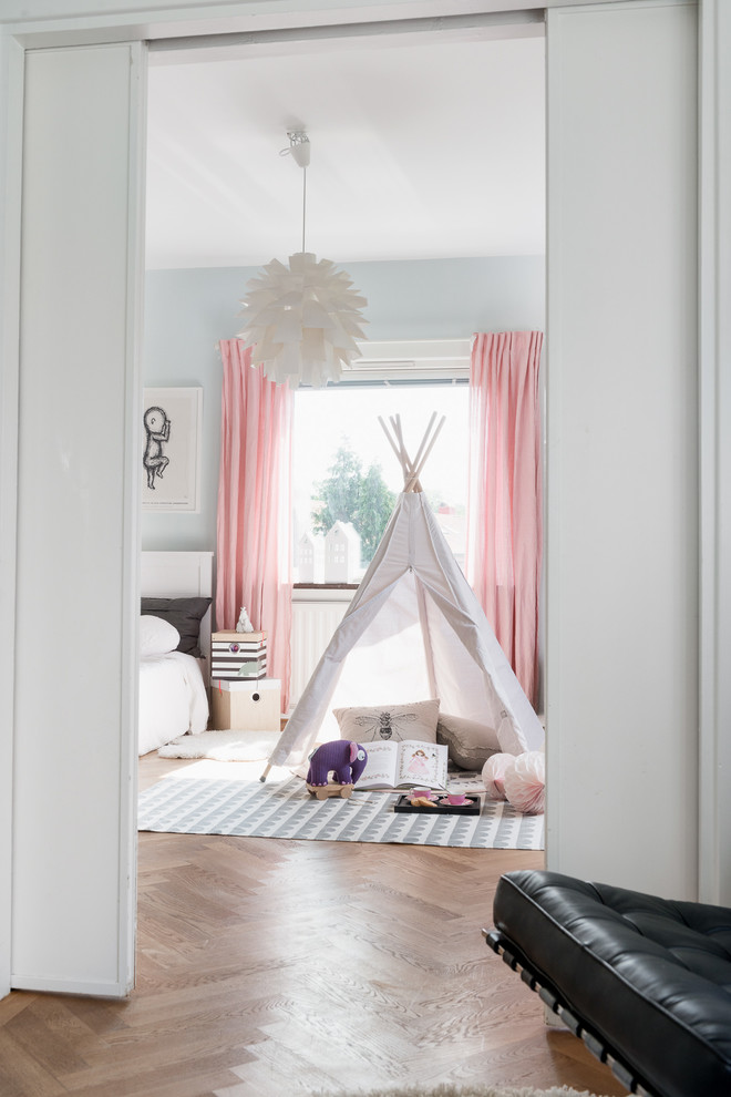 Inspiration for a large scandinavian gender-neutral kids' playroom for kids 4-10 years old in Gothenburg with grey walls and medium hardwood floors.