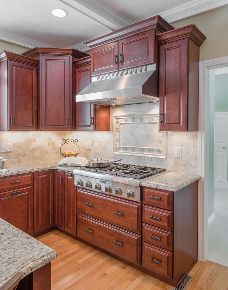 Inspiration for a large transitional light wood floor kitchen remodel in Boston with an undermount sink, medium tone wood cabinets, granite countertops, stone tile backsplash, stainless steel appliances and an island
