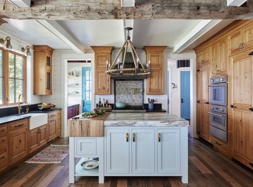 Inspiration för ett rustikt kök, med en rustik diskho, luckor med upphöjd panel, skåp i mellenmörkt trä, granitbänkskiva, mörkt trägolv, en köksö och brunt golv