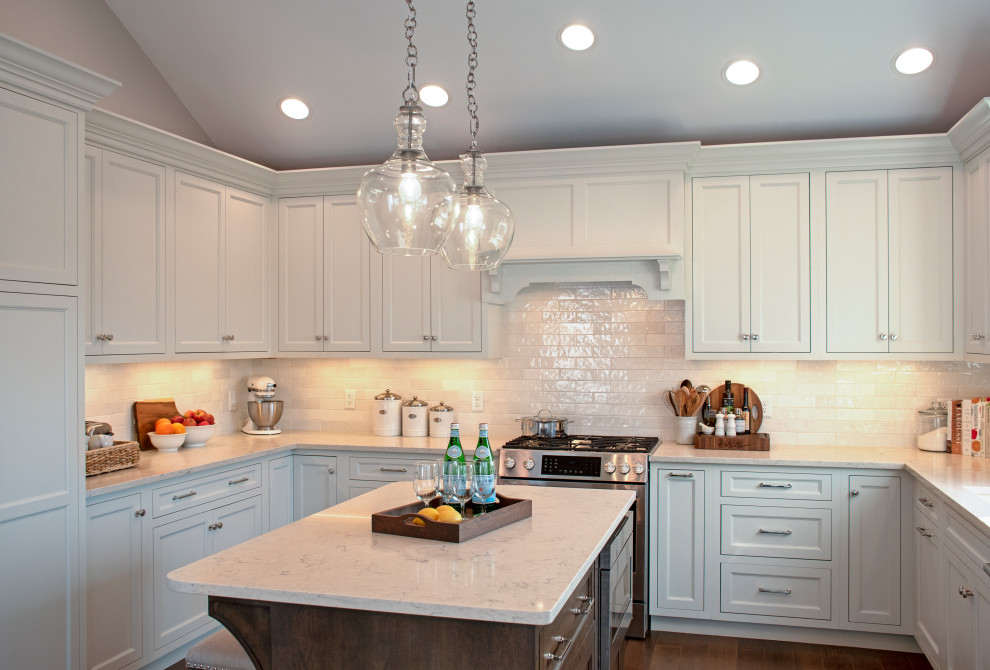 Eat-in kitchen - transitional medium tone wood floor, brown floor and vaulted ceiling eat-in kitchen idea with an undermount sink, shaker cabinets, white cabinets, quartz countertops, white backsplash, ceramic backsplash, stainless steel appliances, an island and white countertops