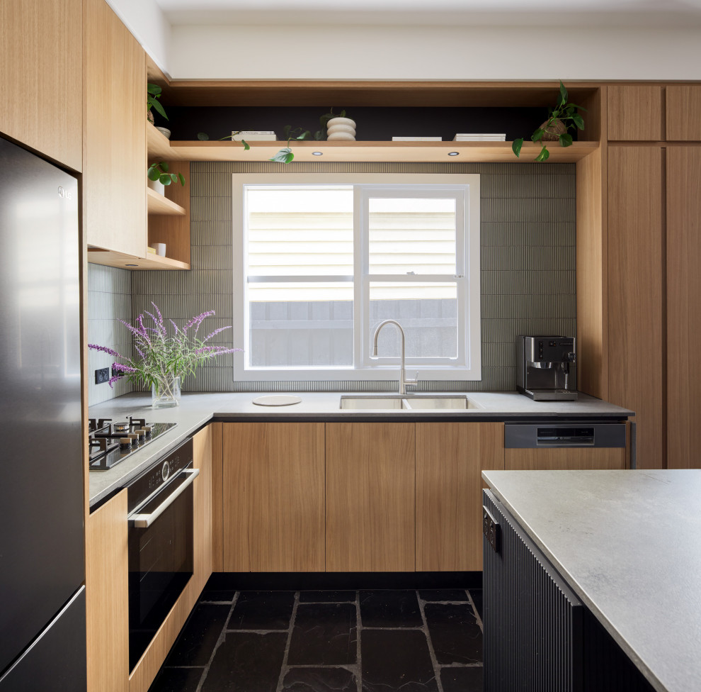 Idéer för att renovera ett mellanstort funkis l-kök, med släta luckor, grönt stänkskydd, stänkskydd i keramik, skiffergolv, en köksö och svart golv