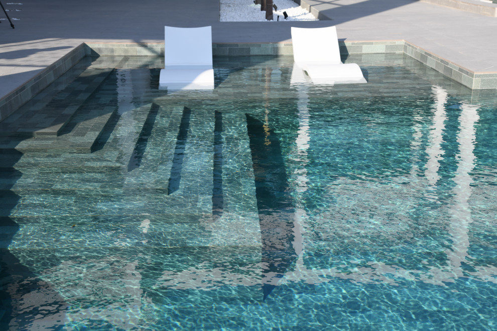 Aménagement d'un piscine avec aménagement paysager arrière exotique de taille moyenne et sur mesure avec du carrelage.