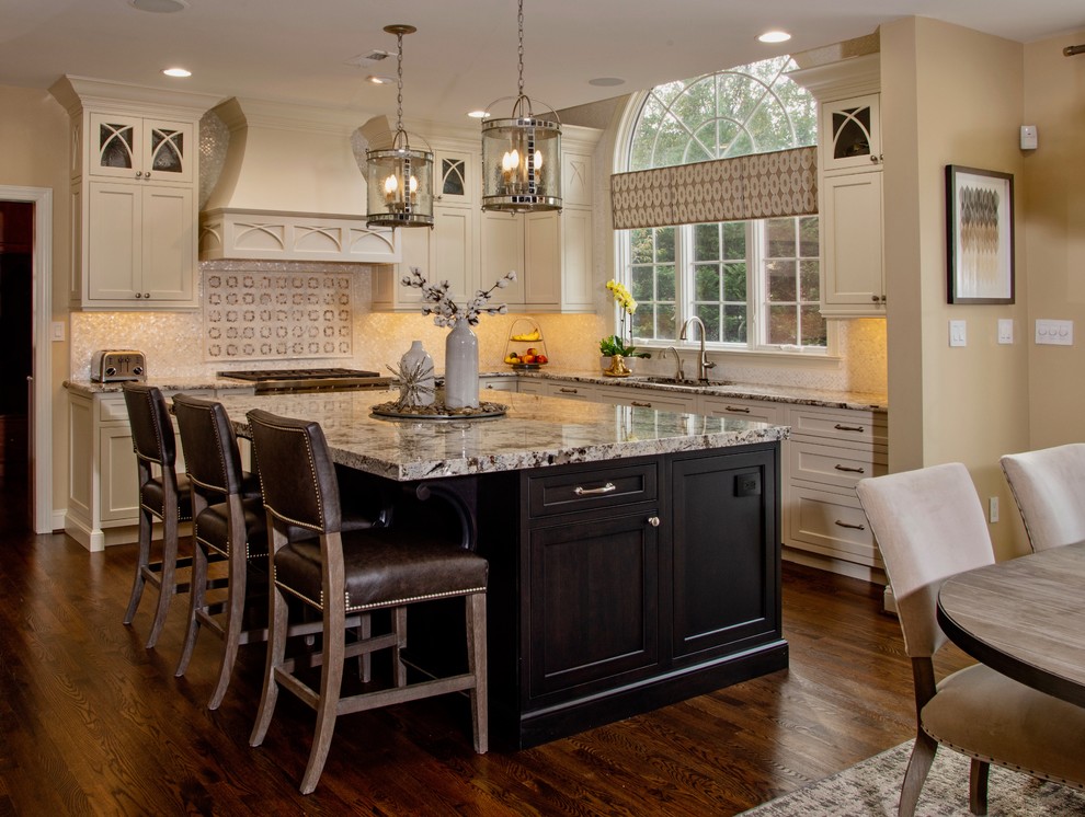 Inspiration for a timeless l-shaped dark wood floor and brown floor kitchen remodel in Philadelphia with an undermount sink, shaker cabinets, beige cabinets, beige backsplash, mosaic tile backsplash, stainless steel appliances, an island and gray countertops