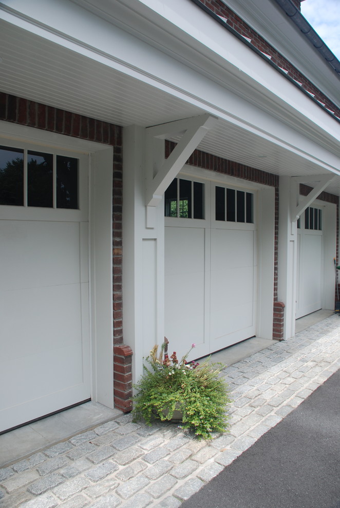 Design ideas for a large traditional attached three-car garage in Other.