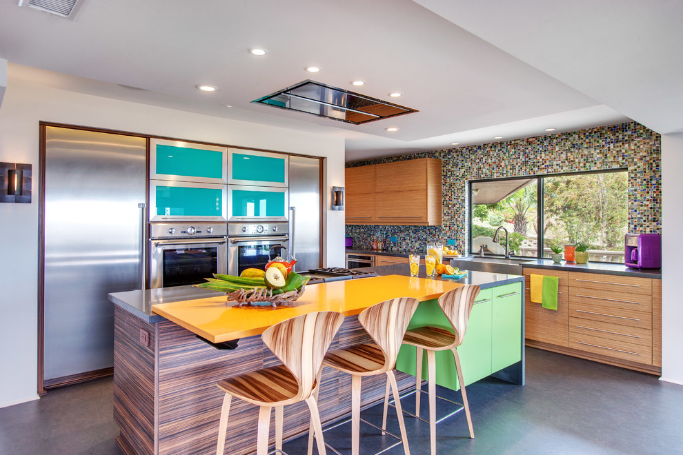 Contemporary kitchen in San Diego with a farmhouse sink, flat-panel cabinets, medium wood cabinets, multi-coloured splashback, mosaic tile splashback, stainless steel appliances and concrete floors.